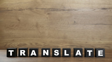 Word Translate made of black cubes with letters on wooden table. Space for textの写真素材