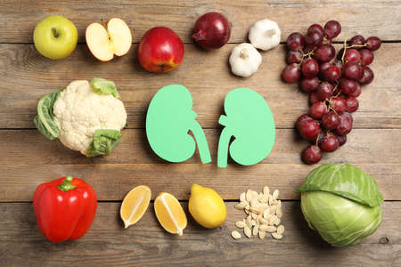 Flat lay composition with paper cutout of kidneys and different products on wooden tableの写真素材
