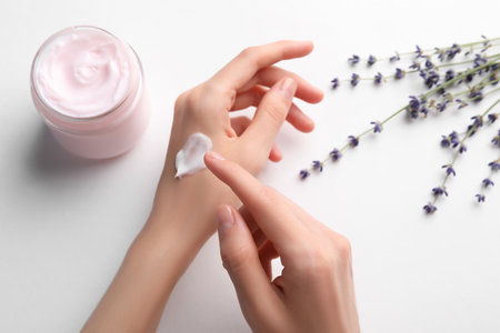 Woman applying hand cream on white background, top viewの写真素材