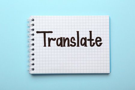 Notebook with written word Translate on light blue background, top viewの写真素材