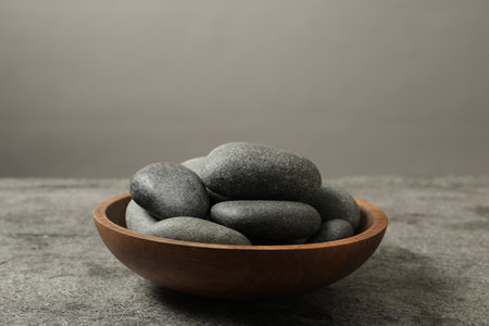 Bowl with spa stones on gray table, closeupの写真素材
