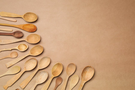 New wooden spoons on brown background, flat lay with space for text. Cooking utensilsの写真素材