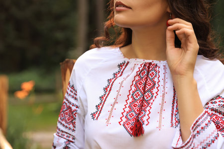 Woman in beautiful embroidered shirt outdoors, closeup. Ukrainian national clothesの写真素材