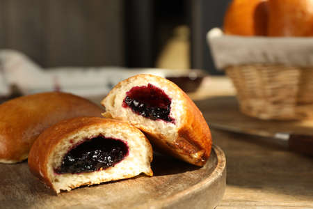 Delicious baked patties with jam on wooden table, closeup