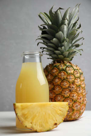 Delicious pineapple juice and fresh fruit on white wooden tableの写真素材