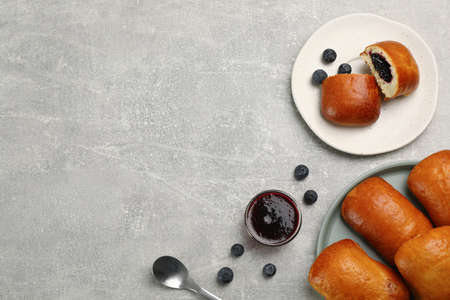 Delicious baked patties with blueberries on light gray table, flat lay. Space for textの写真素材