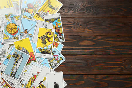 Tarot cards on wooden table, top view. Space for text