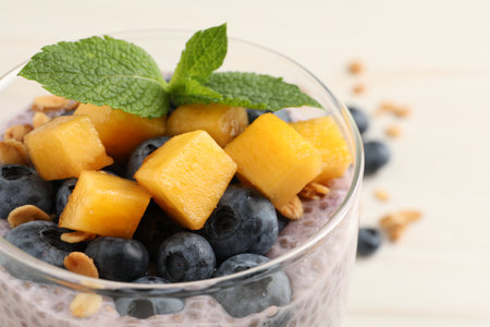 Delicious chia pudding with blueberries, mango and mint in glass on white table, closeupの写真素材