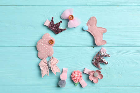 Frame of cute hair clips on light blue wooden table, flat lay. Space for textの写真素材