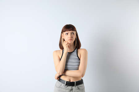 Portrait of confused young girl on white backgroundの写真素材