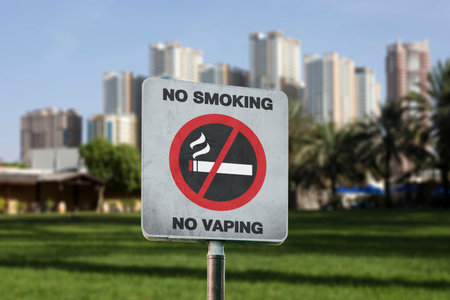 Sign No Smoking and blurred view of green park and cityscapeの写真素材