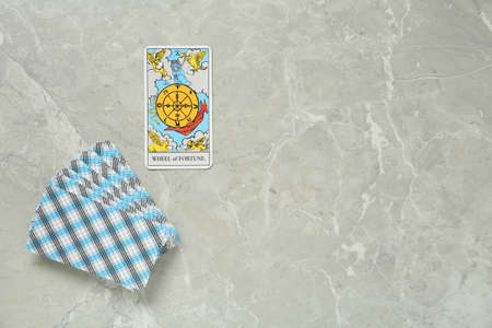 The Wheel of Fortune and other tarot cards on light gray marble table, flat lay. Space for text