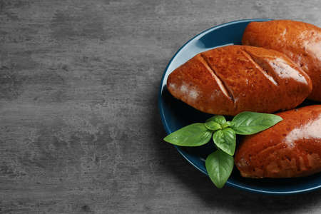 Delicious baked patties and basil on gray table. Space for textの写真素材