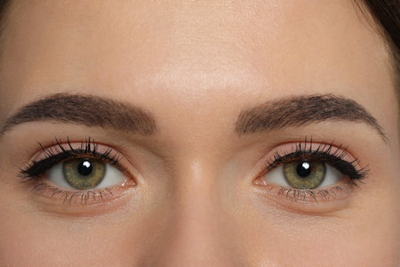 Young woman with permanent makeup of eyes and brows, closeupの写真素材