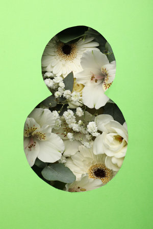 View of beautiful flowers through number 8 shaped hole in green paper. International Women's dayの写真素材