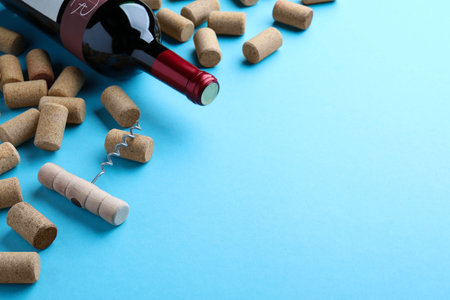 Corkscrew with wine bottle and stoppers on turquoise background. Space for textの写真素材