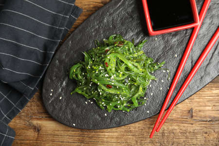 Japanese seaweed salad served on wooden table, flat layの写真素材