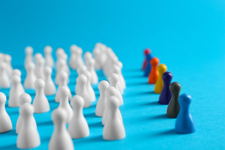 Colorful pawns on light blue background. social inclusion conceptの写真素材