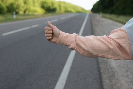 Woman catching car on road, closeup. Hitchhiking tripの写真素材