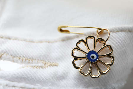 Evil eye safety pin on clothing, closeupの写真素材