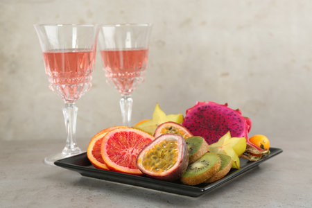 Delicious exotic fruits and wine on gray tableの写真素材