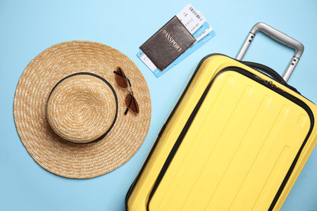 Flat lay composition with passport, tickets and travel items on light blue backgroundの写真素材