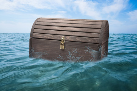 Closed wooden treasure chest floating in the seaの写真素材