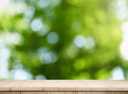 Empty wooden surface against blurred green background. space for design