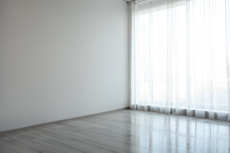 Empty room with white wall, large window and wooden floorの写真素材