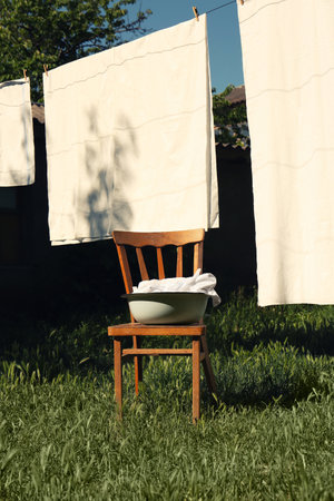 Washing line with clean laundry and clothespins outdoors