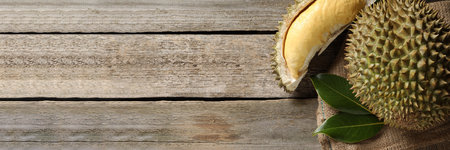Fresh ripe durian fruits on wooden table, top view with space for text. banner designの写真素材