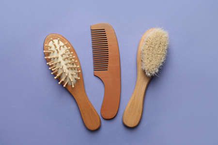 Bamboo brushes and comb on lavender background, flat lay. Conscious consumption