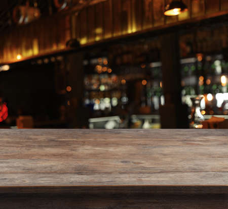 Empty wooden surface and blurred view of bar interior. space for designの写真素材