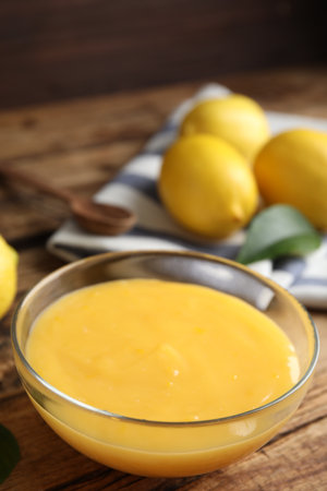 Delicious lemon curd in glass bowl on wooden tableの写真素材