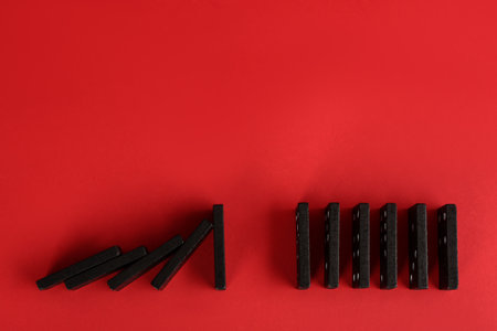 Black domino tiles on red background, flat lay. Space for textの写真素材