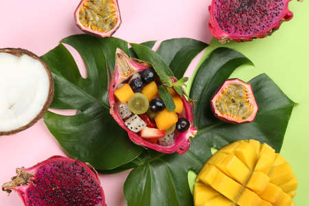 Flat lay composition with delicious exotic fruit salad on color backgroundの写真素材
