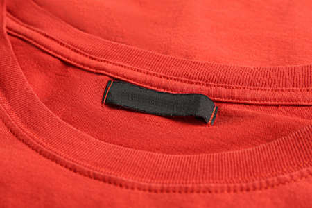 Blank clothing label on red T-shirt, closeup