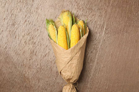 Corn cobs wrapped in parchment on table, top viewの写真素材