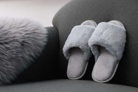 Soft gray slippers and faux fur on sofaの写真素材