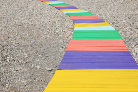 Colorful wooden walkway on pebble beach. Space for textの写真素材