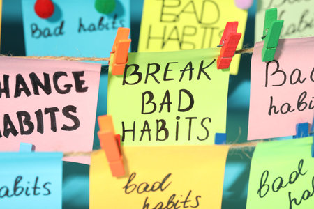 Different paper notes hanging on ropes, closeup. Break bad habits