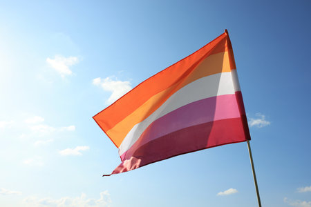 Bright lesbian flag fluttering against blue skyの写真素材