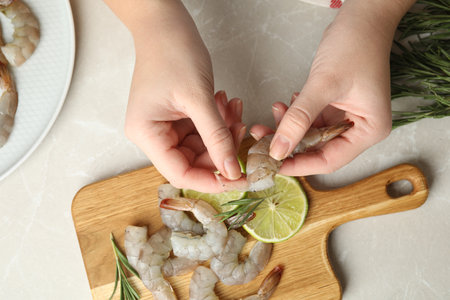 Woman peeling fresh shrimp at table, top viewの写真素材
