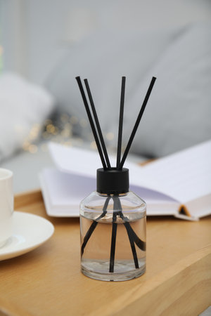 Aromatic reed air freshener on wooden tray in the bedroom