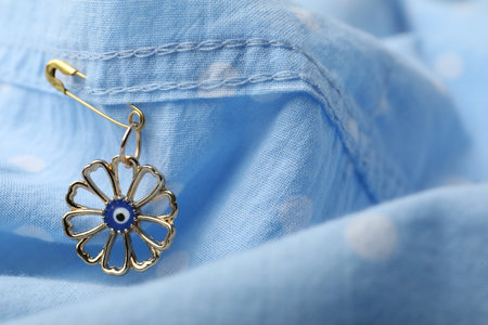 Evil eye safety pin on clothing, closeupの写真素材