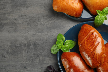 Delicious baked patties and basil on gray table, flat lay. Space for textの写真素材