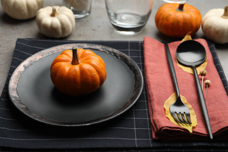 Seasonal table setting with pumpkins and autumn leaves on gray backgroundの写真素材