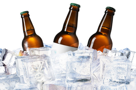 Bottles of beer on ice cubes against white backgroundの写真素材