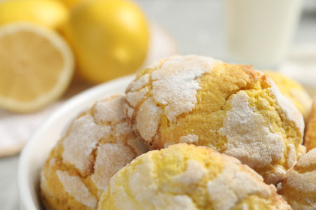 Many delicious lemon cookies in bowl, closeup