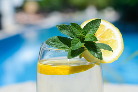 Refreshing water with lemon and mint on blurred background, closeupの写真素材